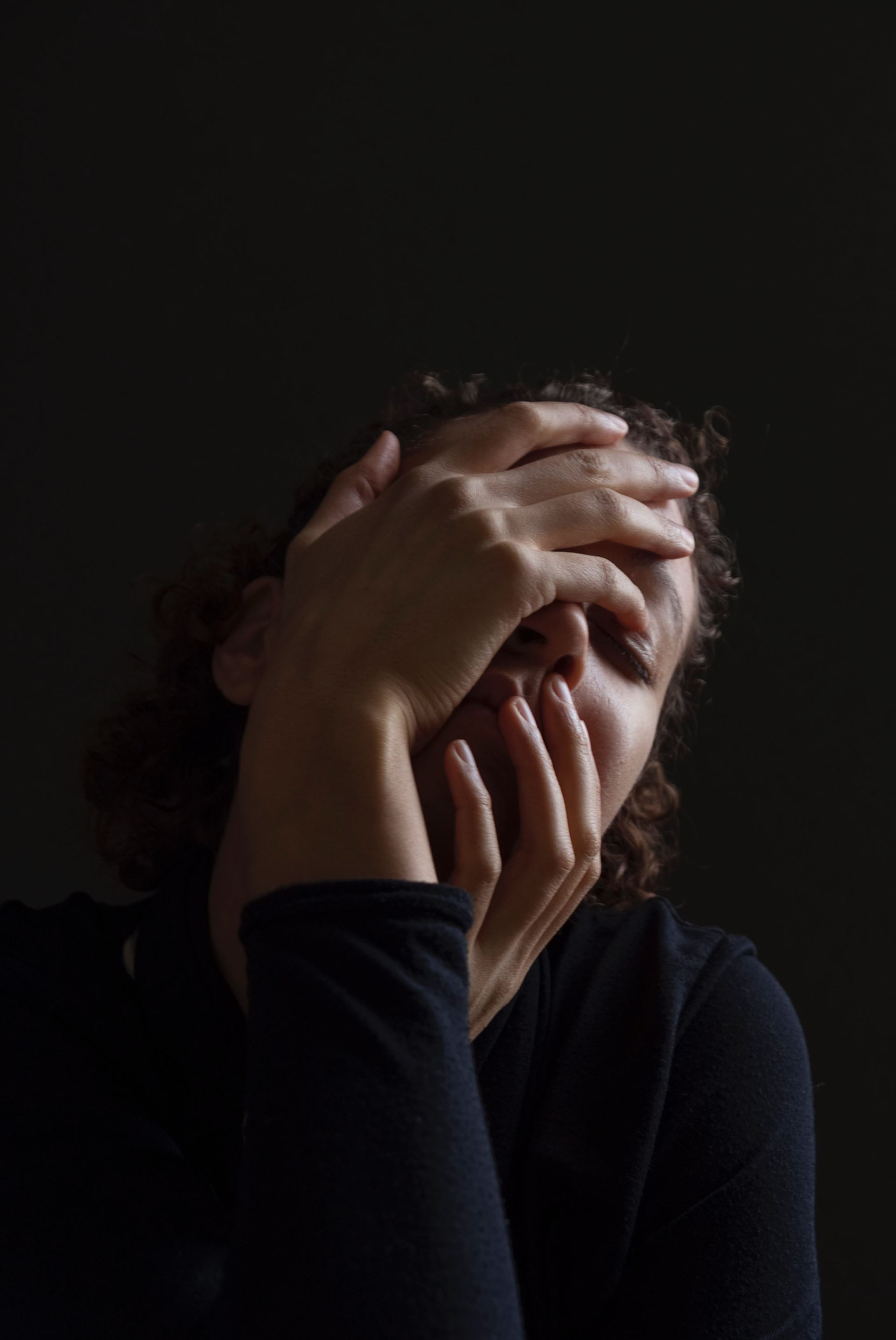 a woman sitting in a dark room